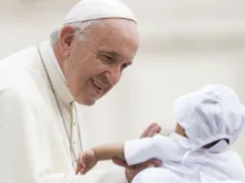 Papa saúda uma criança durante a Audiência Geral.