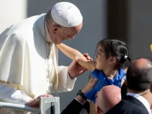 Papa cumprimenta uma menina na Praça de São Pedro.