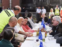 Papa Francisco almoçando com um grupo de pessoas pobres.