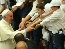 Papa Francisco cumprimenta grupo de crianças.