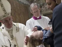 Papa Francisco batiza um bebê no Vaticano em 2016.