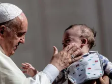 O Papa Francisco abençoa uma criança na Praça de São Pedro, no Vaticano.