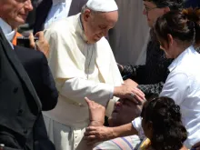Papa Francisco abençoa um idoso enfermo.