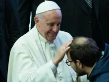 Papa abençoa um jovem.