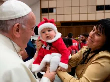 Papa Francisco abençoa uma criança na Sala Paulo VI.
