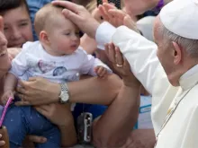 Papa abençoa uma criança durante sua visita a Loppiano.