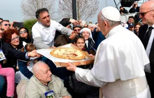 Um homem presenteia o Papa com uma pizza, na qual está desenhado o rosto do Pontífice e de Padre Pio.