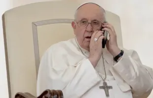 O papa Francisco atende um telefonema durante a Audiência Geral