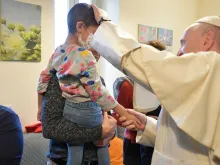 Papa Francisco abençoa uma criança doente na CasAmica Onlus.