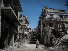 Refugiado percorre ruas destruídas no centro de Homs, na Síria.