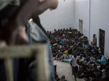 Migrantes esperam em um centro de detenção na Líbia pela oportunidade de viajar para a Europa.