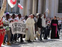 Papa sobe ao palco junto ao grupo de refugiados.