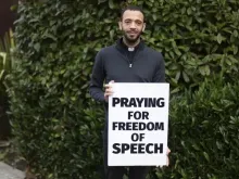 Padre Sean Gough com sua placa dizendo rezo pela liberdade de expressão'