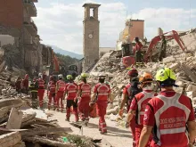 Equipe de resgate da Cruz Vermelha em meio aos escombros após terremoto na Itália.