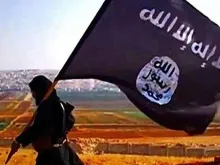 Terrorista com bandeira do Estado Islâmico.