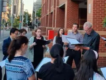 Católicos cantam do lado de fora da prisão de Melbourne na véspera de Natal