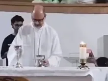 Imagem de vídeo de dom Joaquim Mol em missa de crisma; a crismanda pode ser vista à direita, por trás do altar - Captura de tela