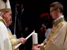 Zane segura o círio pascal enquanto o papa Francisco a acende, na Vigília Pascal no Sábado Santo de 2023 no Vaticano.