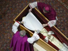 O arcebispo Georg Ganswein e o monsenhor Diego Giovanni Ravelli colocam um véu branco sobre o rosto de Bento XVI antes do caixão ser fechado