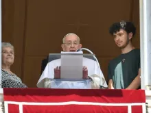 Papa Francisco reza o Ângelus ladeado por uma idosa e um jovem