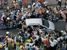 Carro do Papa Francisco cercado de pessoas