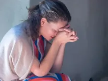 Mulher rezando (imagem ilustrativa