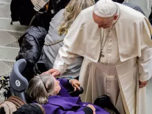 Papa abençoa uma mulher doente durante uma audiência.