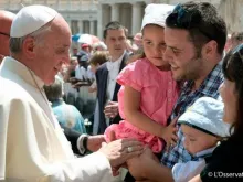 O Papa Francisco com uma família na Praça de São Pedro. Foto L'Osservatore Romano