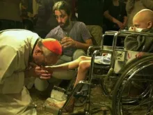 O então Cardeal Bergoglio, agora Papa Francisco, lavando os pés a um pequeno em cadeira de rodas