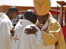 Padre Michael Mithamo King'ori abraça dom Anthony Muheria no dia de sua ordenação
