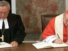 Cardeal Cassidy e o bispo luterano Christian Krause assinam declaração conjunta.