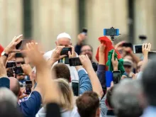 Papa Francisco no Vaticano cercado por pessoas com seus celulares.